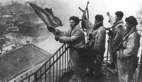 Советские солдаты поднимают красный флаг над освобожденной Гатчиной, 26 января 1944 г.