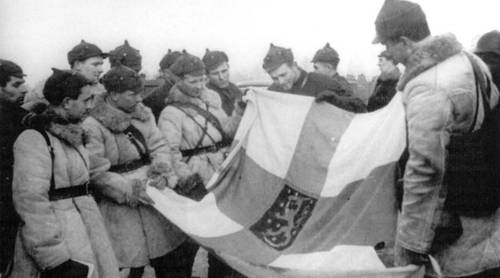 Комсостав (на переднем плане) и рядовые красноармейцы с захваченным флагом Финляндии