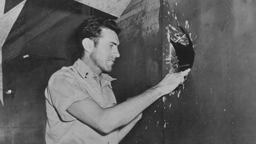 Первый лейтенант Замперини осматривает пробоину в своём бомбардировщике B-24 Liberator, сделанную над Науру, 18 апреля 1943 года.