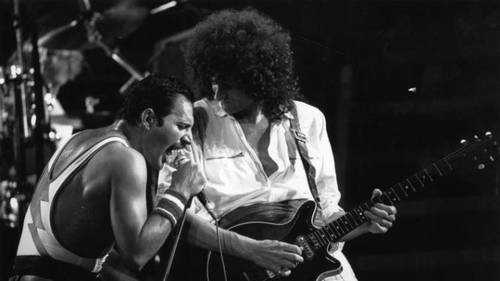 Гитарист Брайан Мэй, певец Фредди Меркьюри и рок-группа «Queen» во время концерта